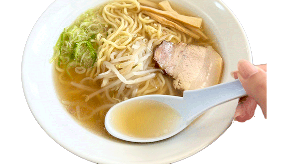 透き通ったスープを蓮華ですくった様子